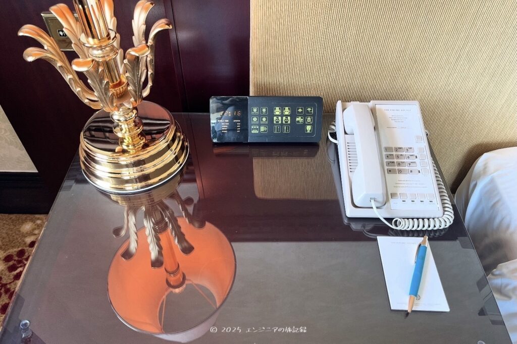 The Empire Bruneiのスーペリアルームのベッド横の机