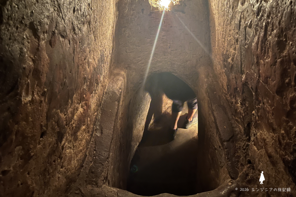 ベトナム戦争時代のトンネルを見学する旅行者の様子