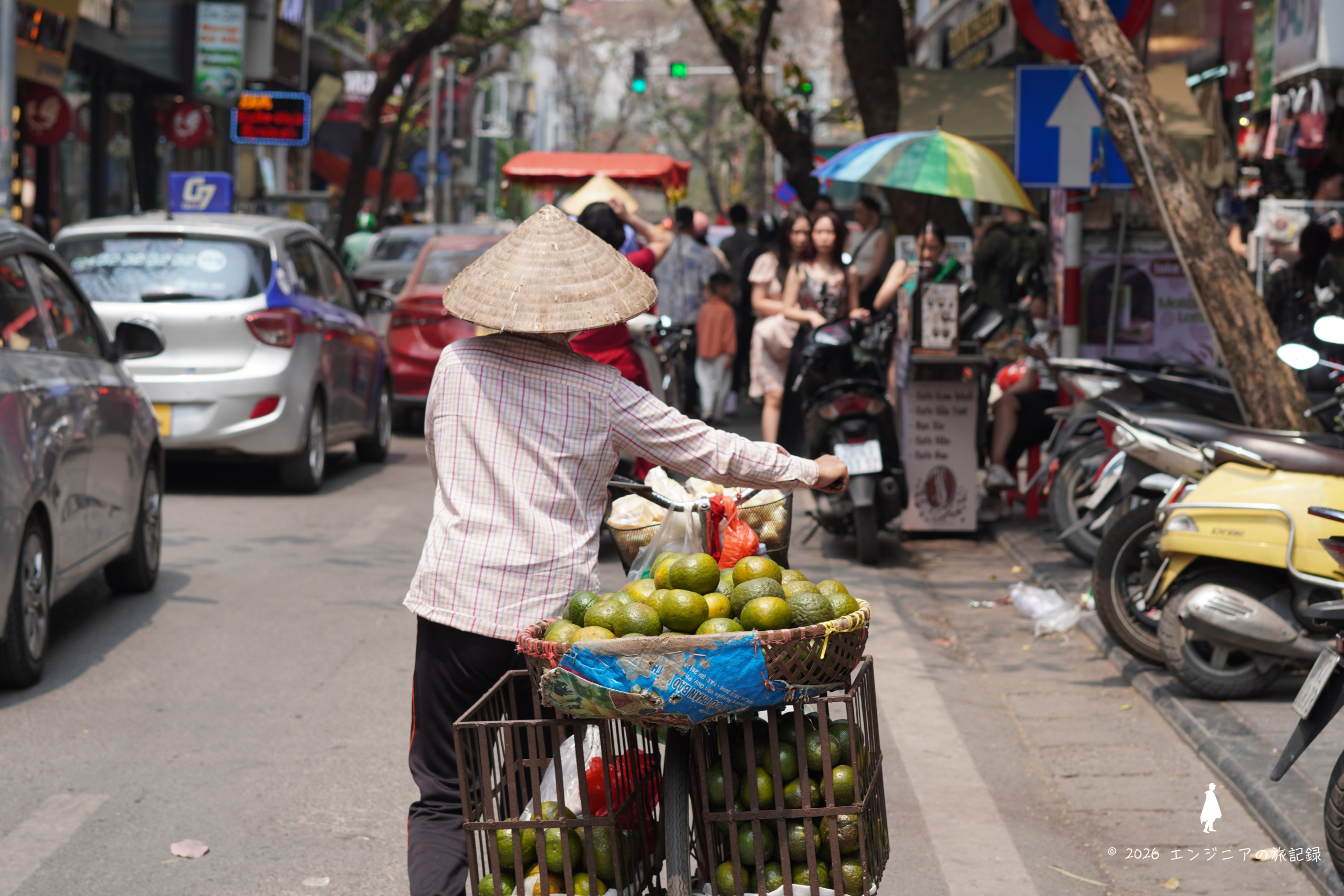 ハノイ旧市街のバイクが行き交う活気ある路地の風景